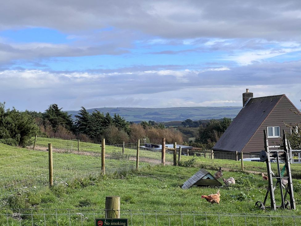 A view of a farmhouse with chickens and a fence at Farmhouse Sleeps 5 Near Alton Towers Peak District, Shorwell