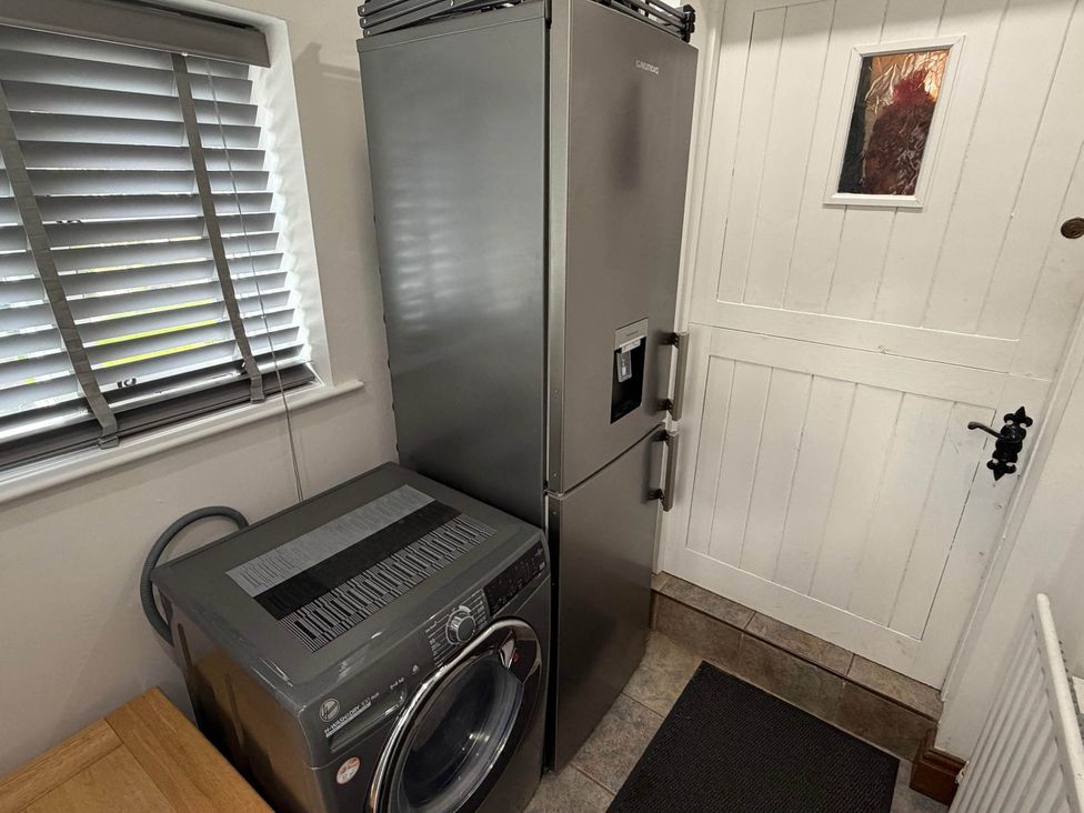 A refrigerator and a washing machine in a utility room at Farmhouse Sleeps 5 Near Alton Towers Peak District in Cheadle