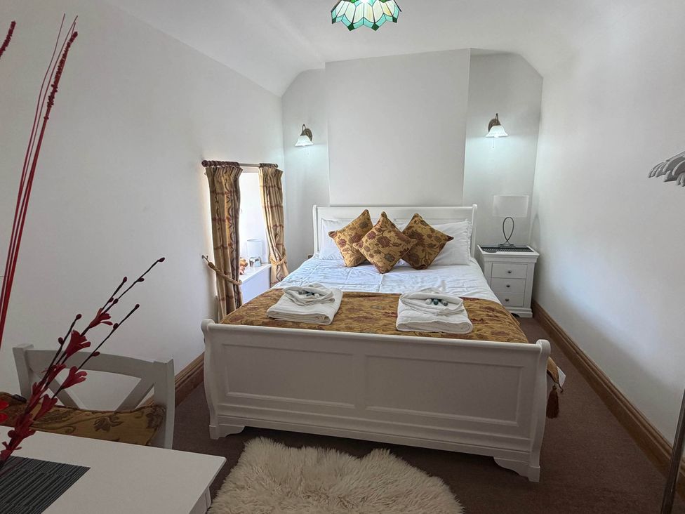 A bedroom with a bed and nightstand at Farmhouse Sleeps 5 Near Alton Towers Peak District, Cheadle