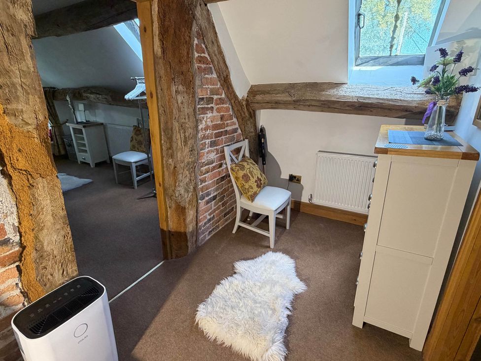 A bedroom with a window and a chair at Farmhouse Sleeps 5 Near Alton Towers Peak District Cheadle
