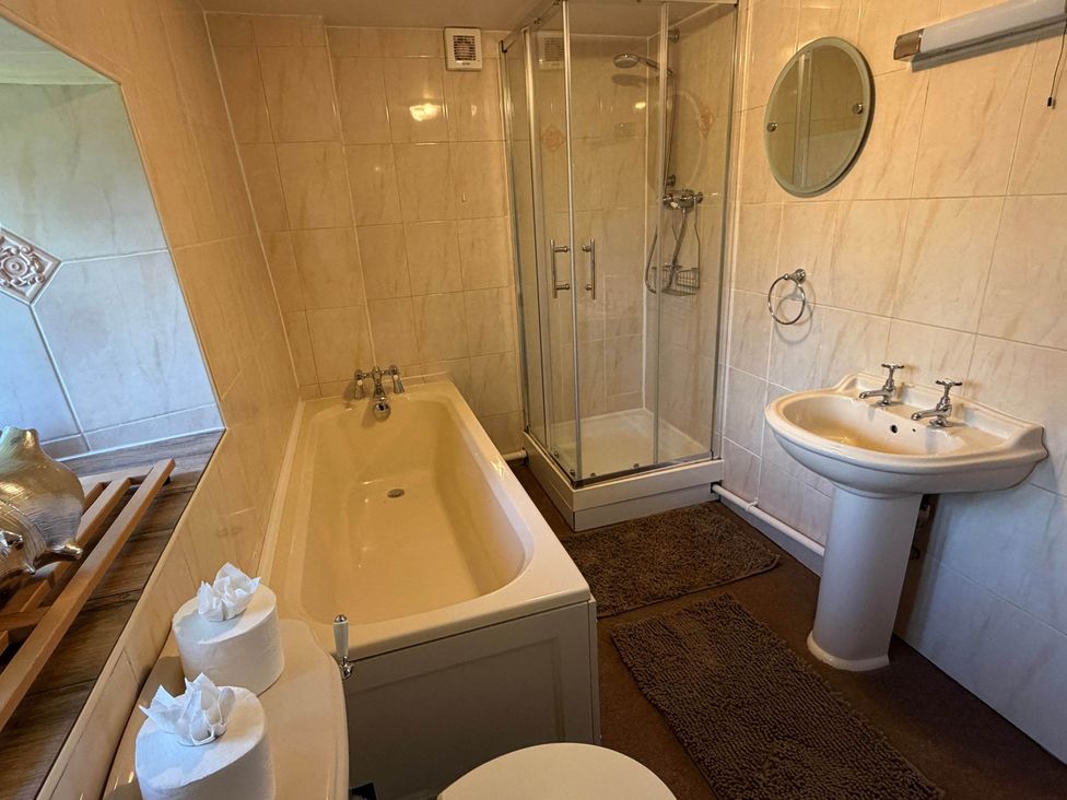 A bathroom with a bathtub and shower at Farmhouse Sleeps 5 Near Alton Towers Peak District Cheadle