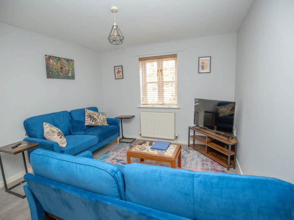 A living room with a sofa and television at House Sleeps 4 with Parking and Garden in Glastonbury