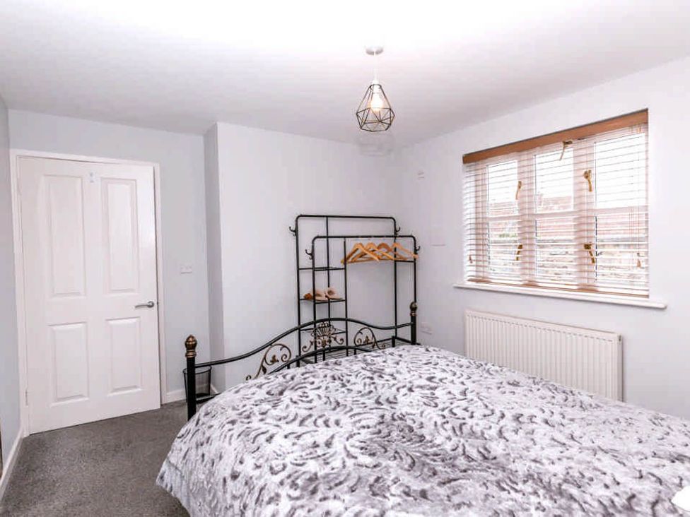 A bedroom with a bed and a clothes rack at House Sleeps 4 with Parking and Garden in Glastonbury