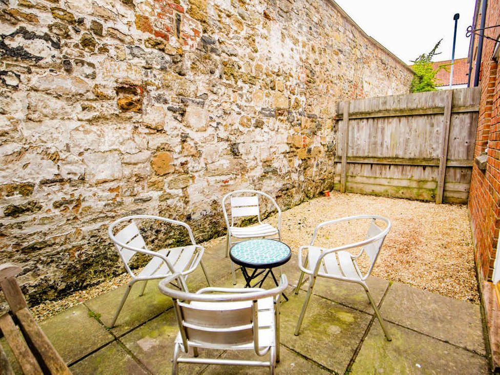 A garden with a stone wall and seating area at House Sleeps 4 with Parking and Garden in Glastonbury