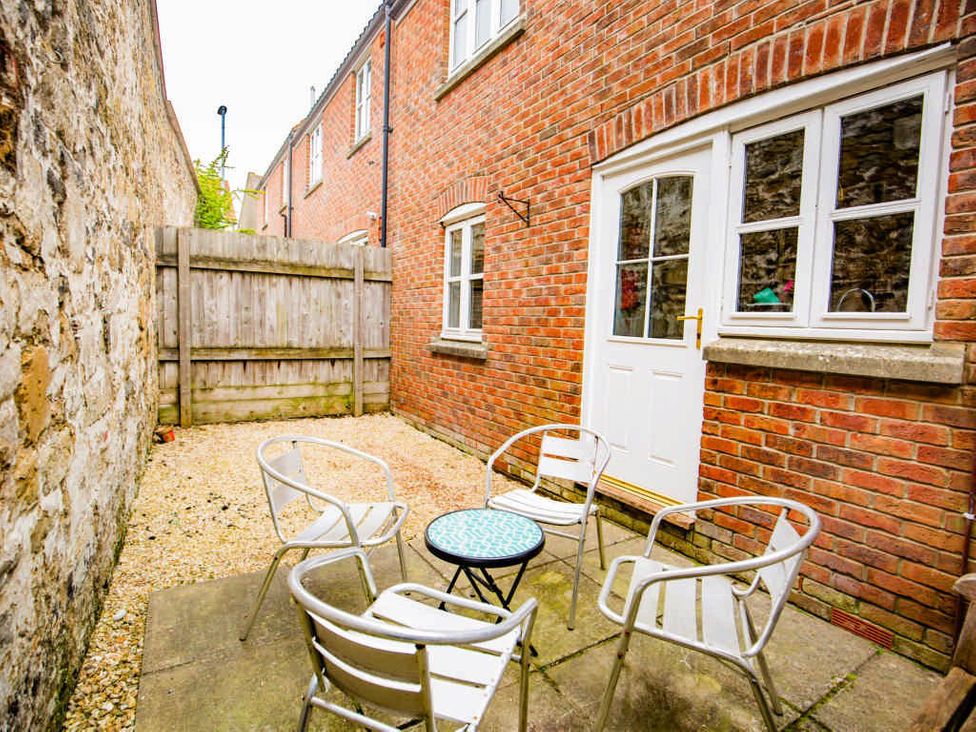 A garden with a table and chairs at House Sleeps 4 with Parking and Garden in Glastonbury
