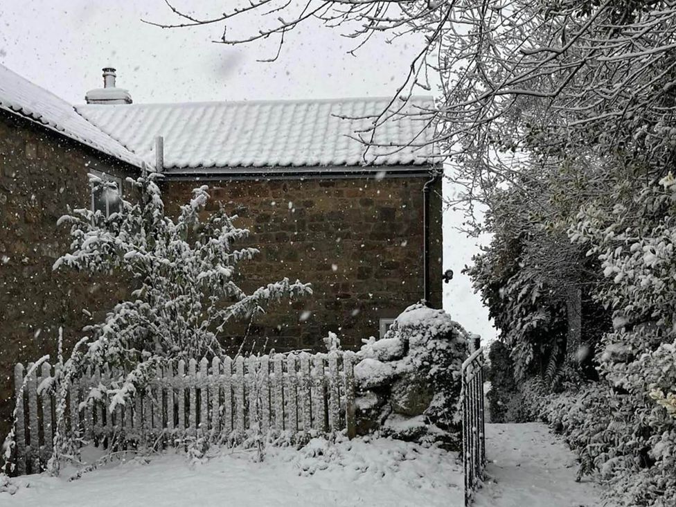 A snowy outdoor view of a house and garden at Stunning 3 Bedroom Cottage near Historic York Ampleforth