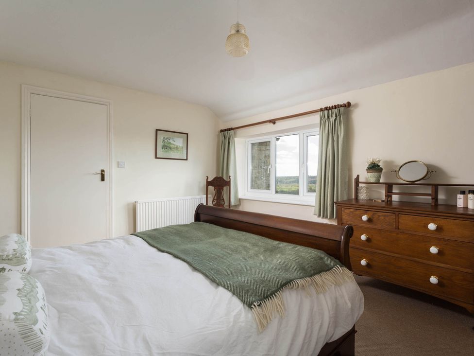 A bedroom with a bed and dresser at Stunning 3 Bedroom Cottage near Historic York in Ampleforth