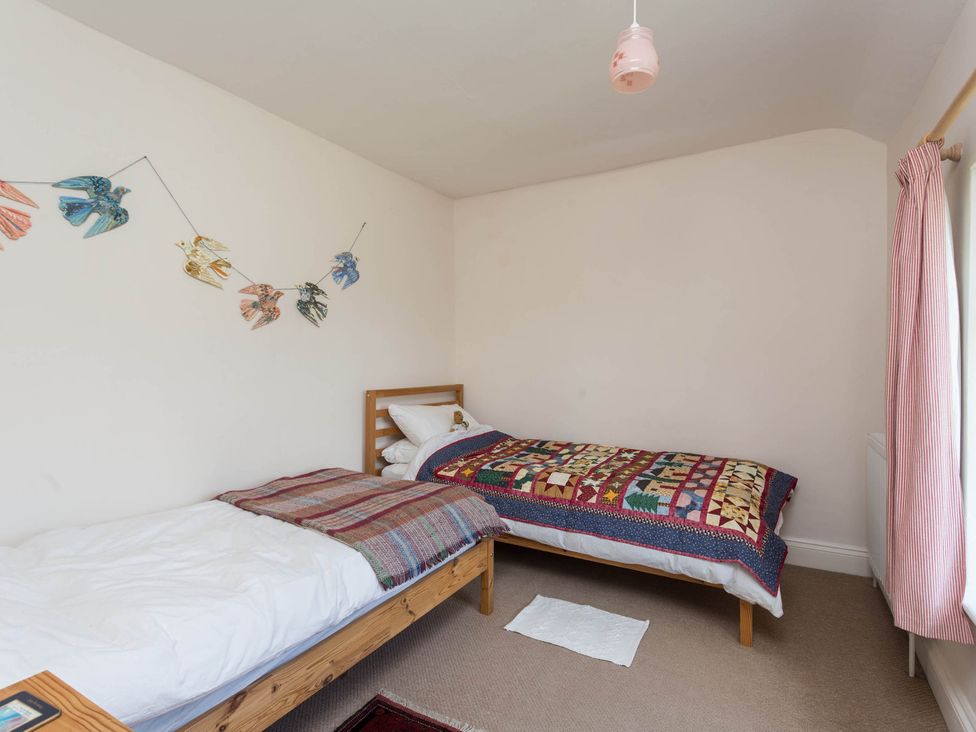 A bedroom with two beds and a garland of birds at Stunning 3 Bedroom Cottage near Historic York Ampleforth