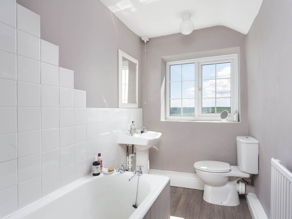 A bathroom with a bathtub, sink, and toilet at Stunning 3 Bedroom Cottage near Historic York Ampleforth