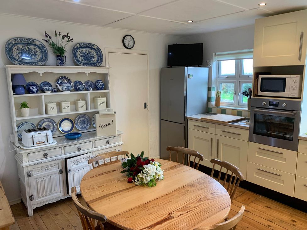 A kitchen with a table and chairs at House Sleeps 8 Close to Beach Free parking in Mullion