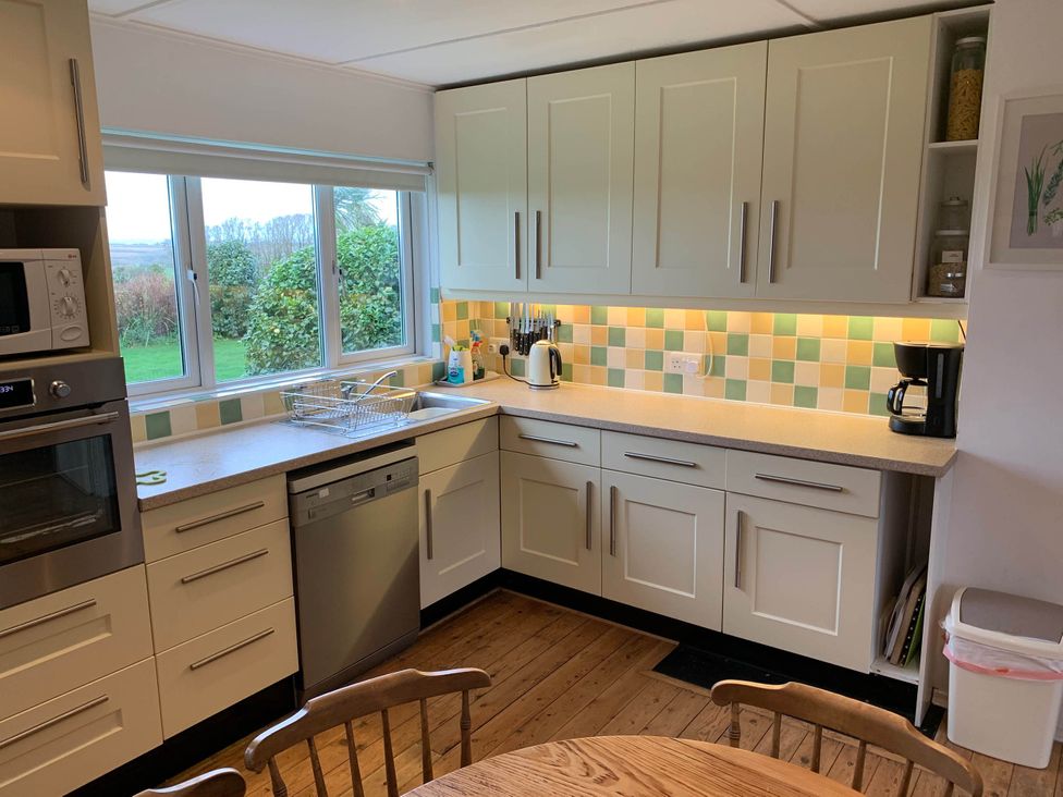 A kitchen with cabinets and appliances at House Sleeps 8 Close to Beach Free parking, Mullion