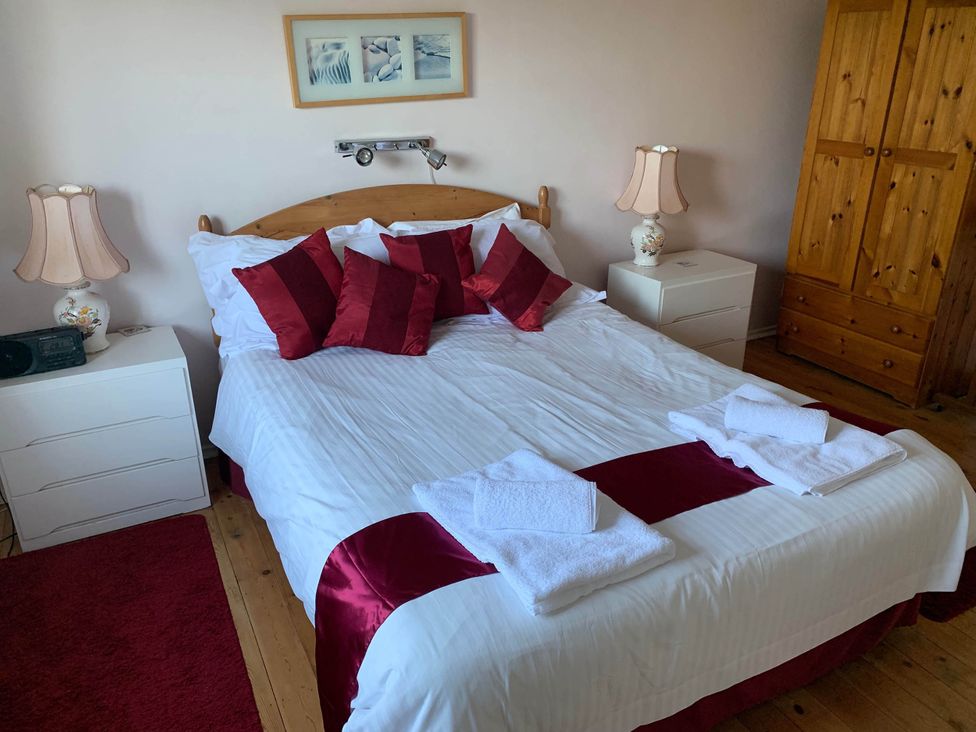 A bedroom with a bed, bedside lamps, and a dresser at House Sleeps 8 Close to Beach Free parking, Mullion