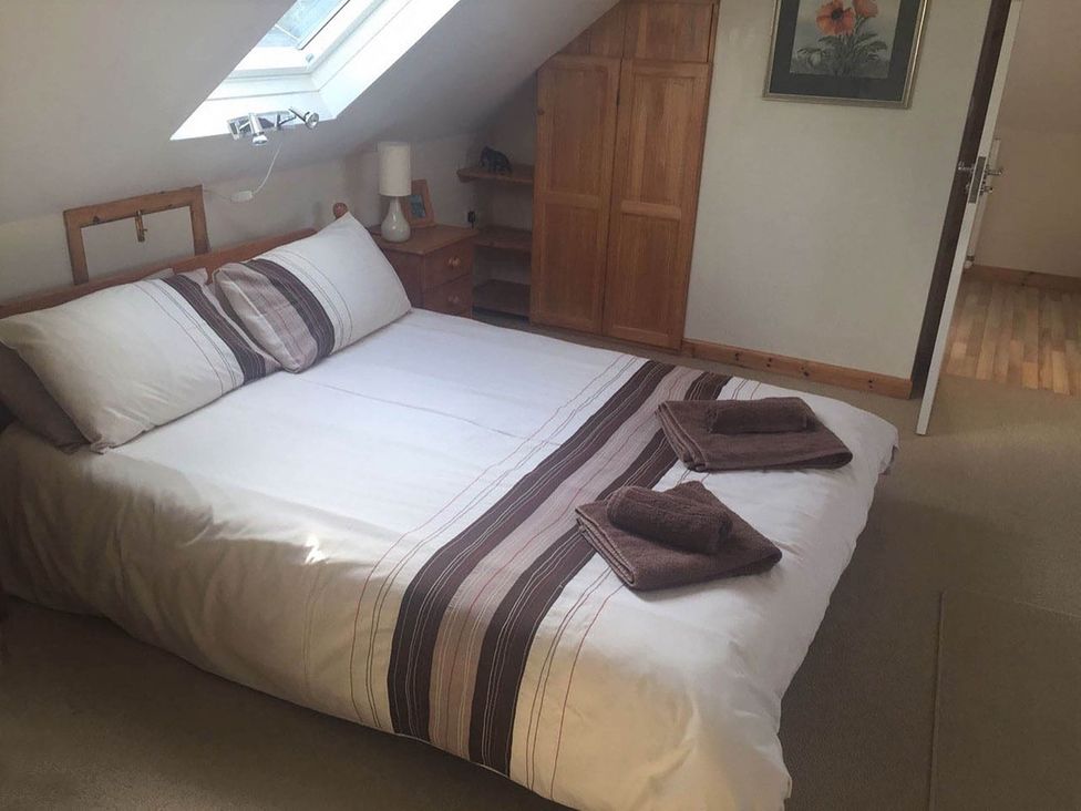 A bedroom with a bed and bedside lamp at House Sleeps 8 Close to Beach Free parking in Mullion