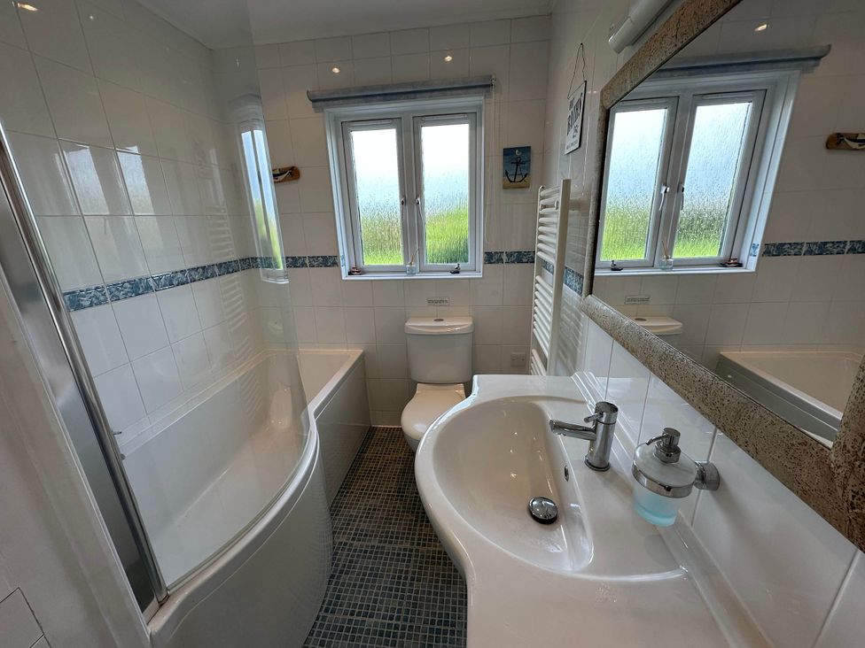 A bathroom with a bathtub and sink at House Sleeps 8 Close to Beach Free parking, Mullion