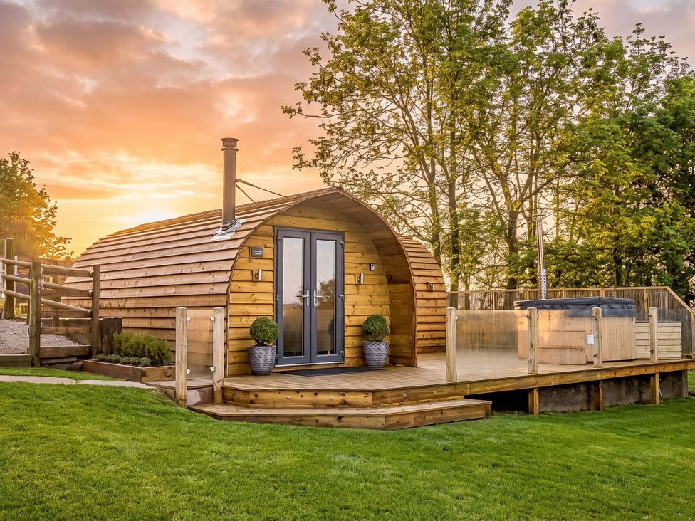 A wooden cabin with a deck and hot tub at The Lodge at Brambles Farm Sleeps 4 Hot Tub in Leek
