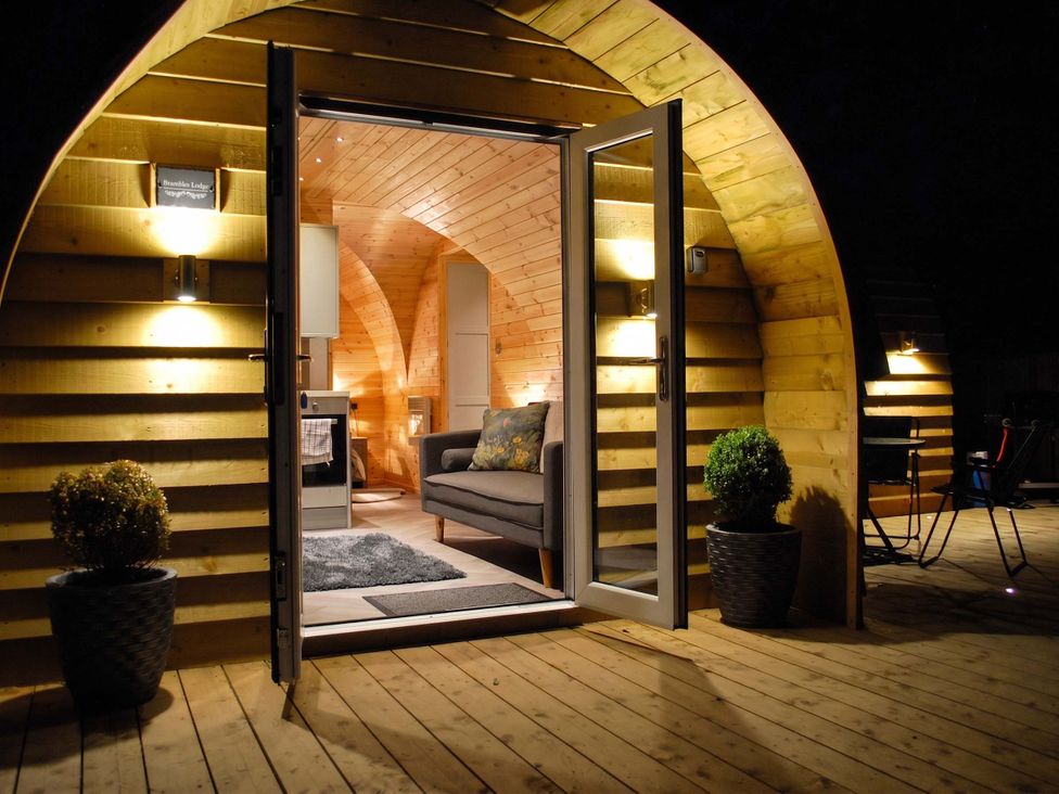 A living room with a couch and door at The Lodge at Brambles Farm Sleeps 4 Hot Tub in Leek