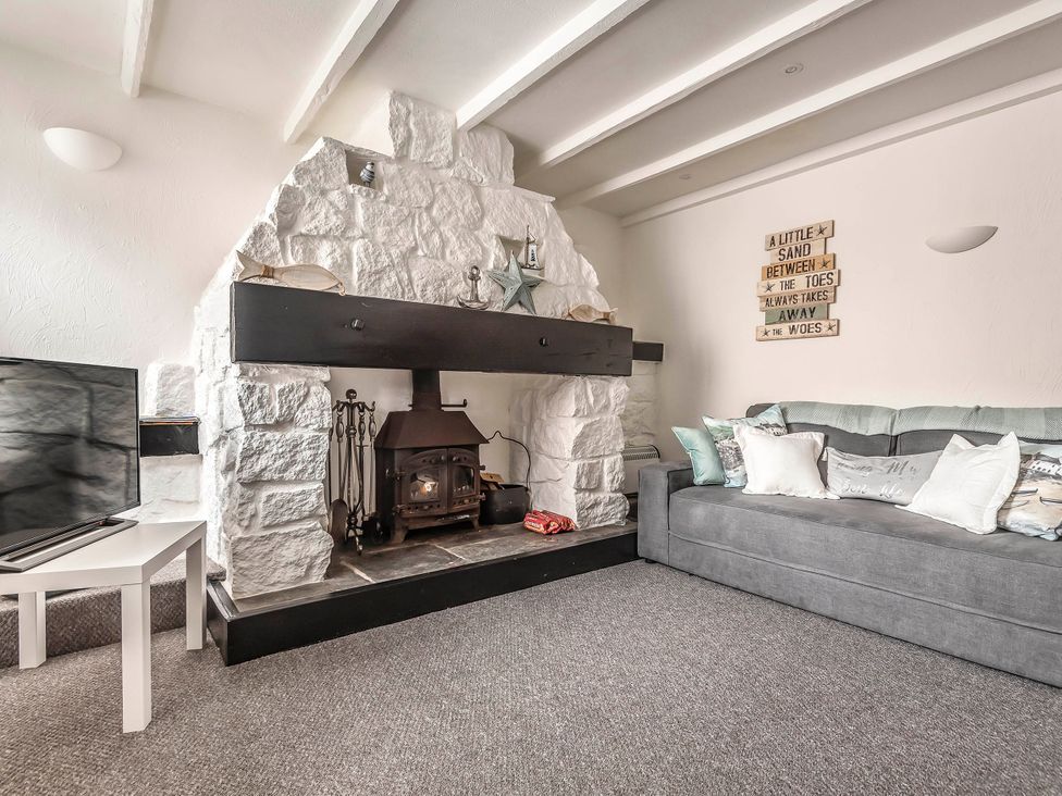 A living room with a fireplace and a sofa at Cottage Sleeps 6 Pet friendly Patio in Saint Austell