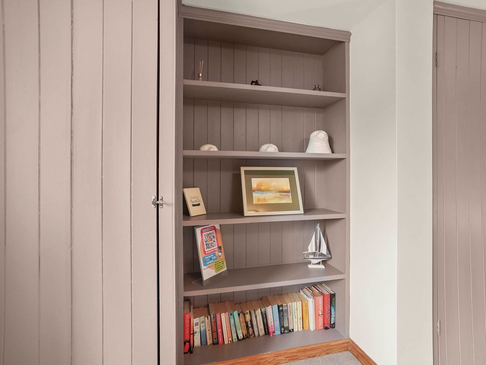 A shelf with books, picture frame, and decorative items at 1880s Barn Conversion Sleeps4 Pet Friendly in Hereford
