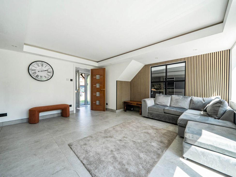 A living room with a clock and sofa at Aylesbury Sleeps 6 Parking Central Location Aylesbeare