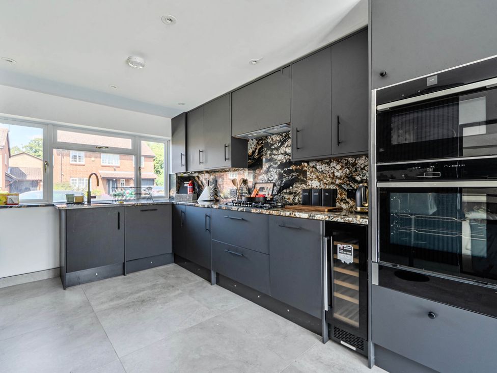 A kitchen with cabinets, sink, stove and oven at Aylesbury Sleeps 6 Parking Central Location Aylesbeare