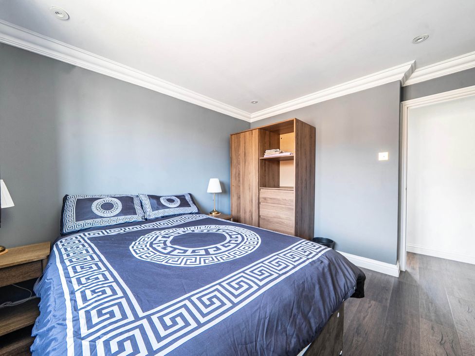 A bedroom with a bed and wardrobe at Aylesbury Sleeps 6 Parking Central Location Aylesbeare