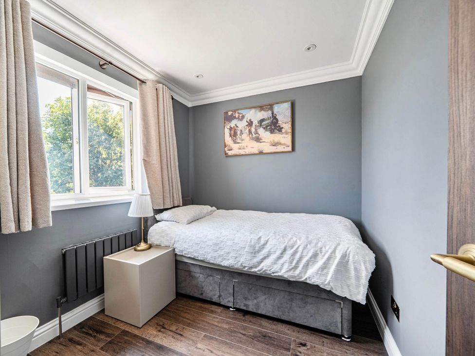 A bedroom with a bed and a window at Aylesbury Sleeps 6 Parking Central Location Aylesbeare