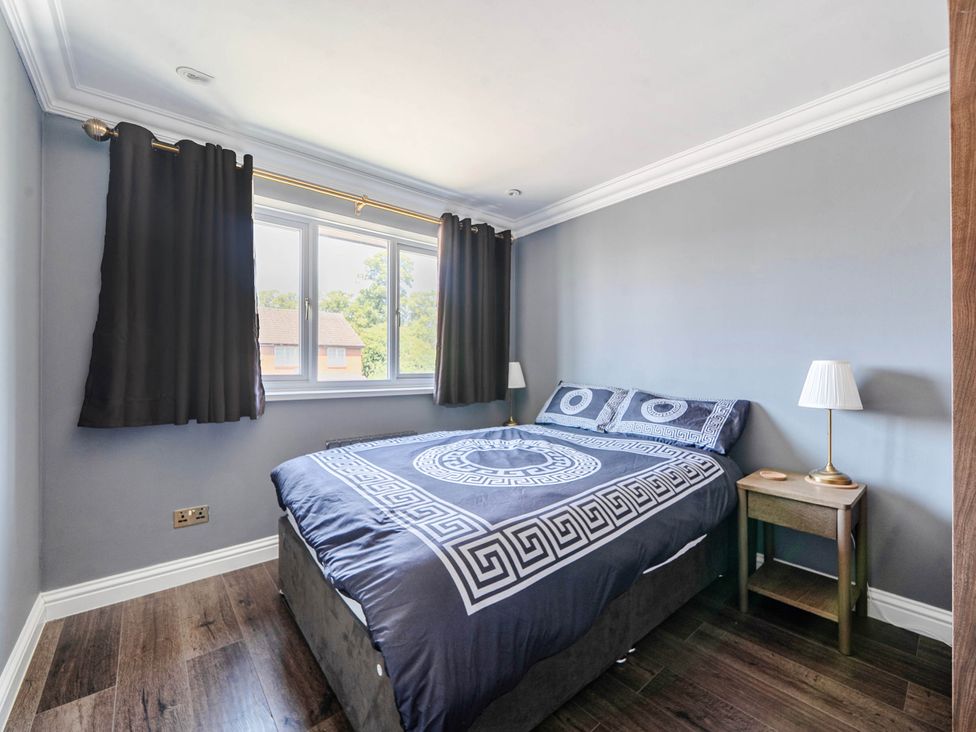 A bedroom with a bed and nightstand at Aylesbury Sleeps 6 Parking Central Location Aylesbeare
