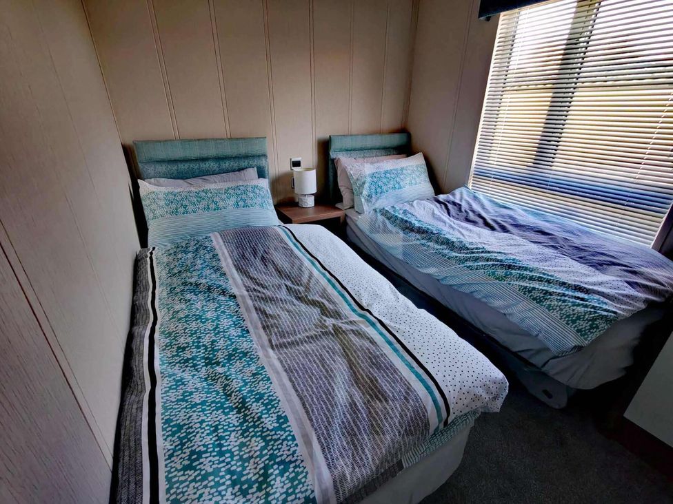 A bedroom with two beds and a bedside table at Dunoon 3Bed Lodge Sleeps 6 Pet Friendly near Dunoon