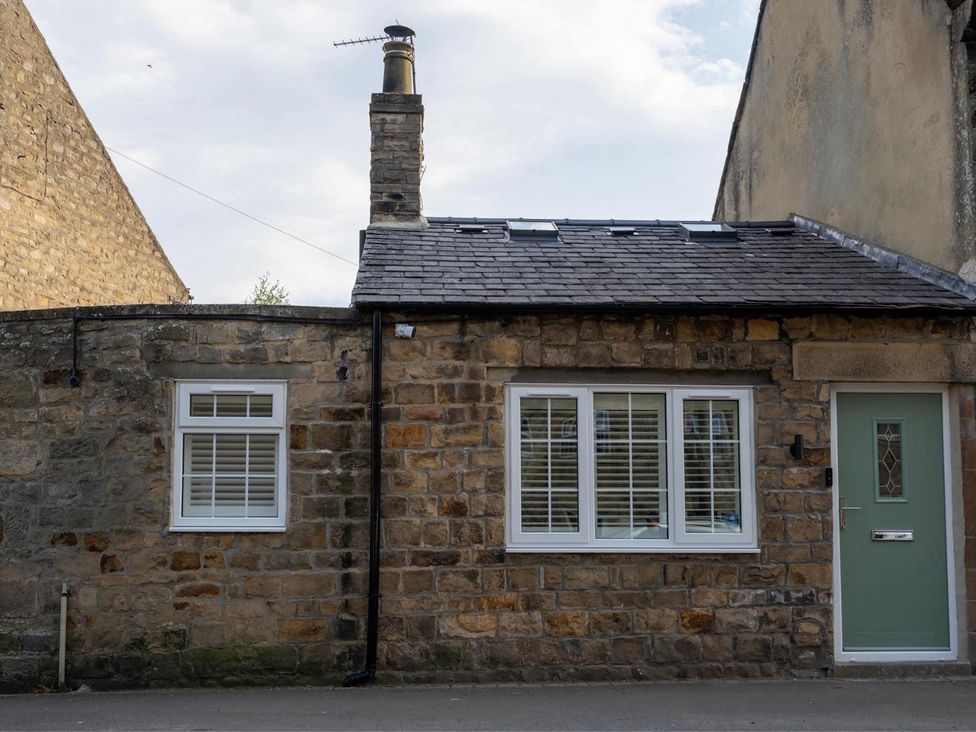 A stone cottage with windows and a green front door at High Spec 1Bed Cottage in Staindrop