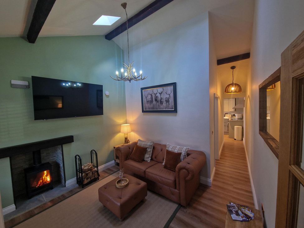 A living room with a sofa, tv, and fireplace at High Spec 1Bed Cottage in Staindrop