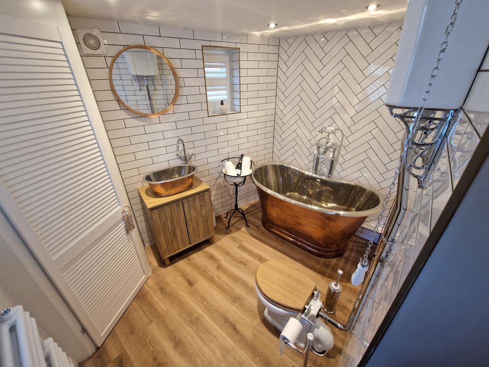 A bathroom with a bathtub, sink, and toilet at High Spec 1Bed Cottage in Staindrop