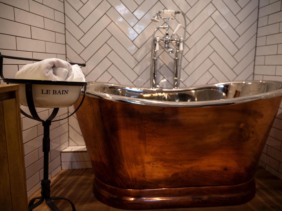 A bathroom with a bathtub and towel rack at High Spec 1Bed Cottage in Staindrop