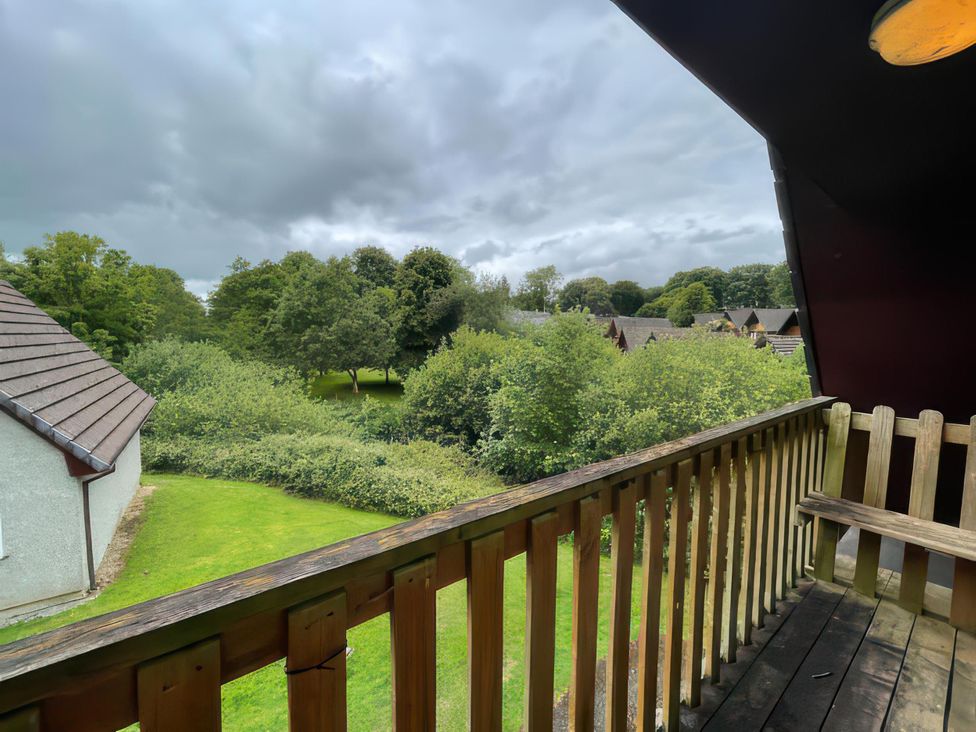 A balcony view of trees and grass at Cosy 3 Bedroom House on Cornish estate with pool St Tudy
