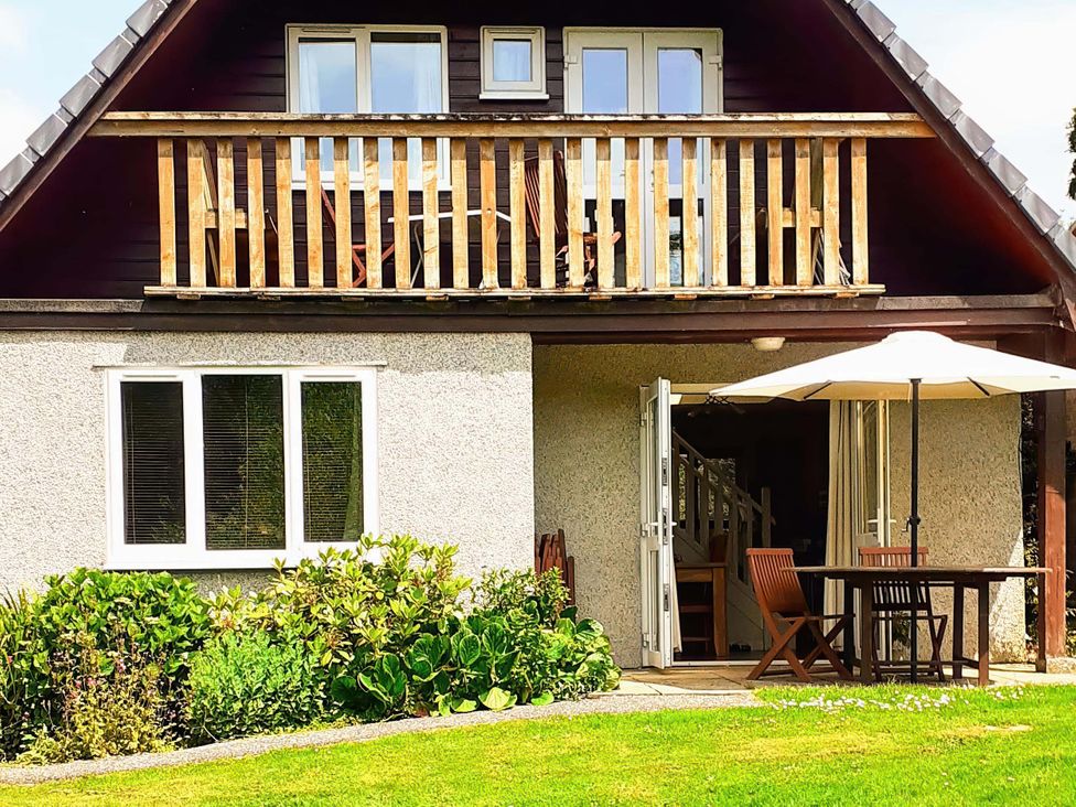A house exterior with a balcony, table with chairs, and plants at Cosy 3 Bedroom House on Cornish estate with pool St Tudy