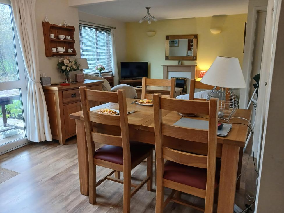 A dining room with a wooden table and chairs at Cosy 3 Bedroom House on Cornish estate with pool St Tudy