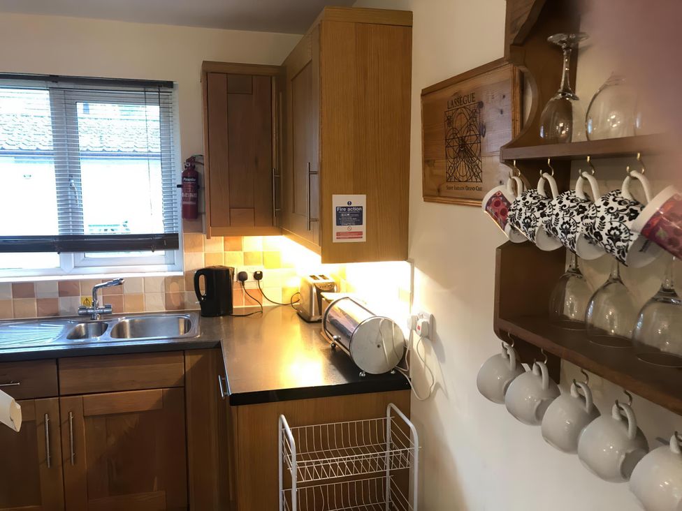 A kitchen with sink, window, and storage cabinets at Cosy 3 Bedroom House on Cornish estate with pool St Tudy