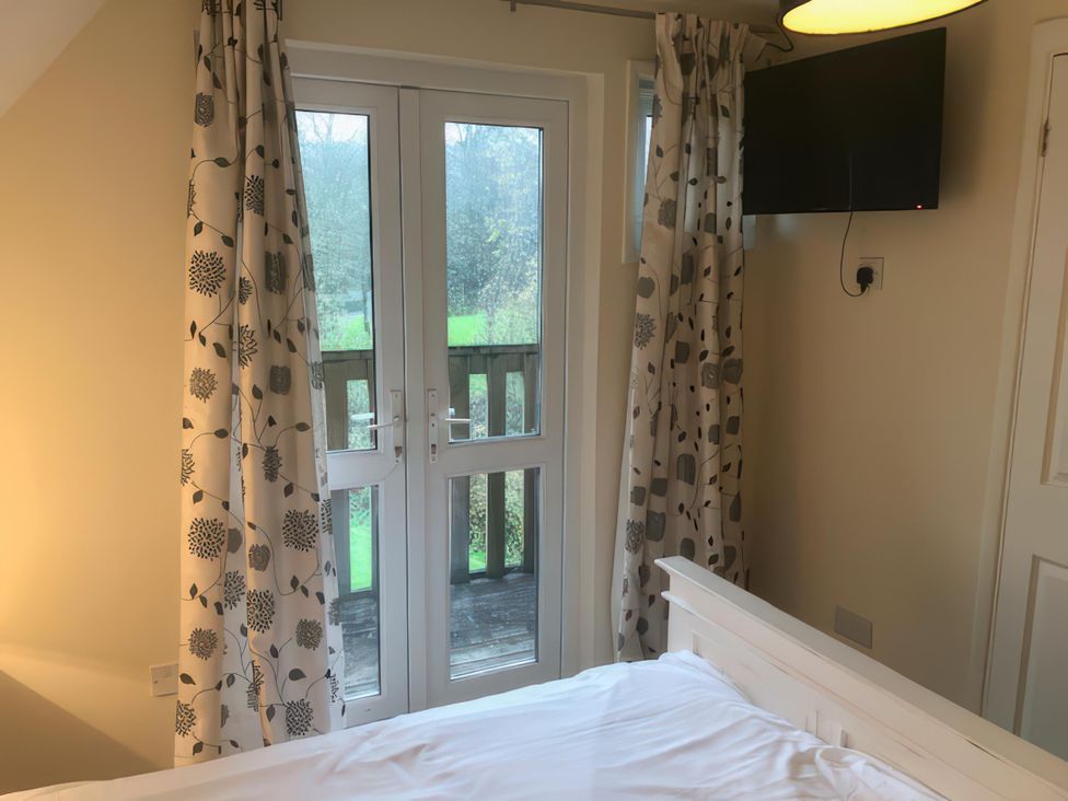 A bedroom with a bed and a television at Cosy 3 Bedroom House on Cornish estate with pool St Tudy