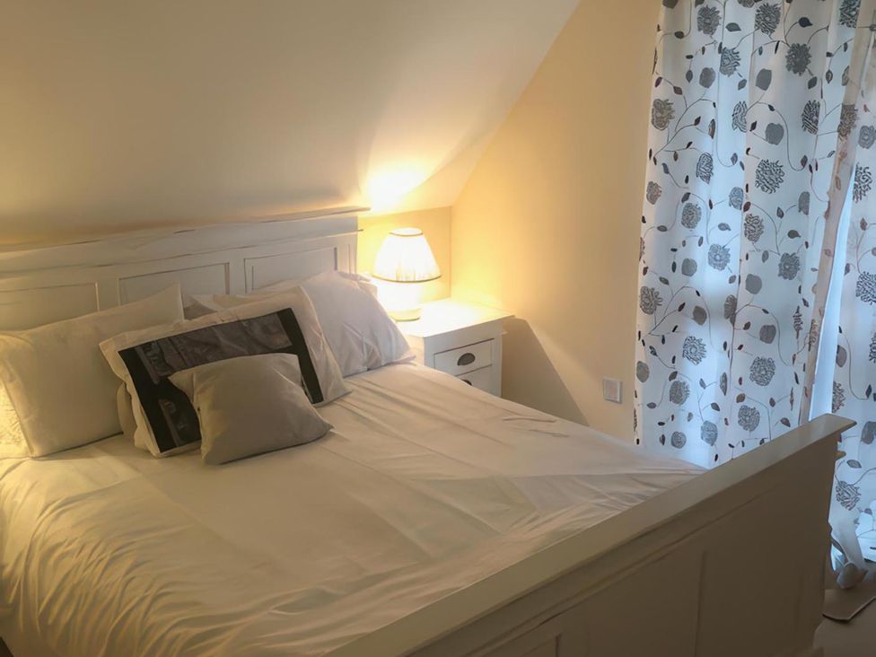 A bedroom with a bed and nightstand at Cosy 3 Bedroom House on Cornish estate with pool in St Tudy