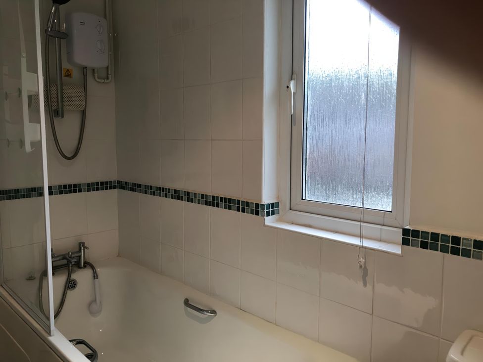 A bathroom with a bathtub and showerhead at Cosy 3 Bedroom House on Cornish estate with pool St Tudy
