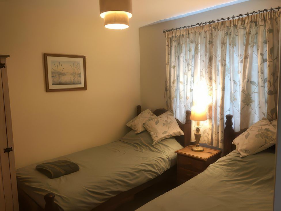 A bedroom with two single beds and a lamp in Cosy 3 Bedroom House on Cornish estate with pool St Tudy