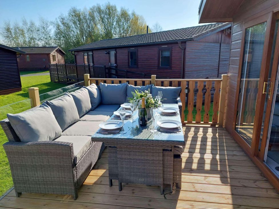 An outdoor patio with seating and a table at Lakeland Lodge 3Bed 2 Bath Private Patio, Carnforth