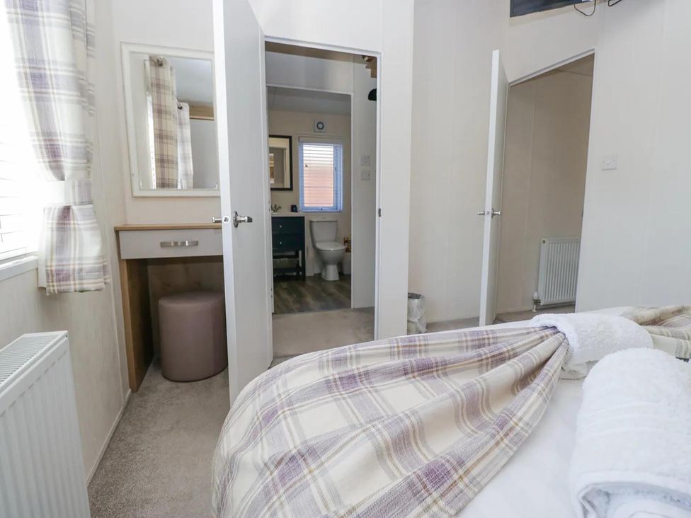 A bedroom with a mirror and doorway leading to a bathroom at Lakeland Lodge 3Bed 2 Bath Private Patio in Carnforth