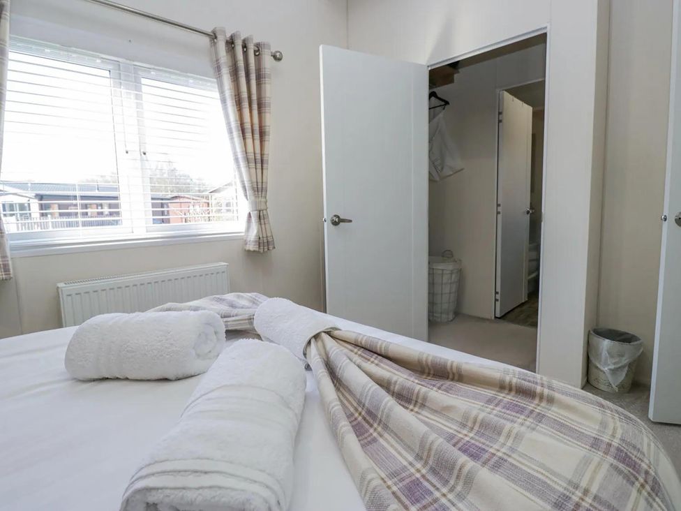 A bedroom with a bed and towels at Lakeland Lodge 3Bed 2 Bath Private Patio in Carnforth
