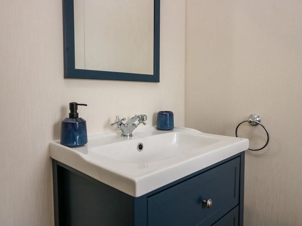 A sink with a mirror and soap dispenser at Lakeland Lodge 3Bed 2 Bath Private Patio in Carnforth