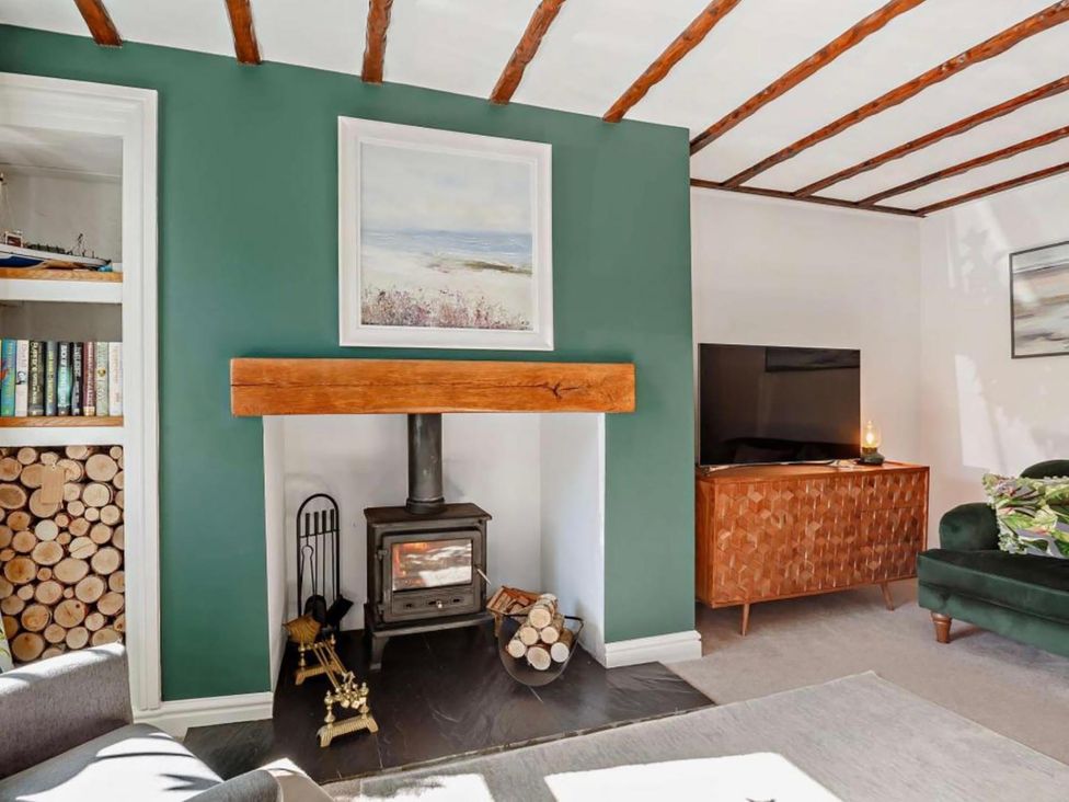 A living room with a fireplace and a television at Cottage Sleeps 5 with Parking and Garden in Carreglefn