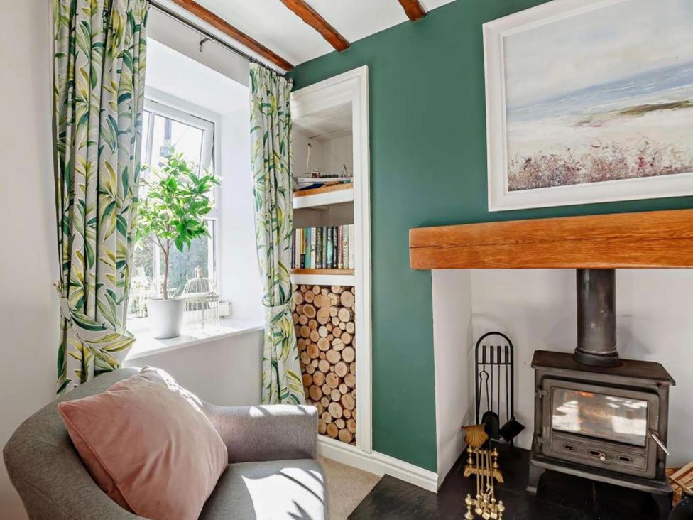 A living room with a fireplace and bookshelves at Cottage Sleeps 5 with Parking and Garden in Carreglefn