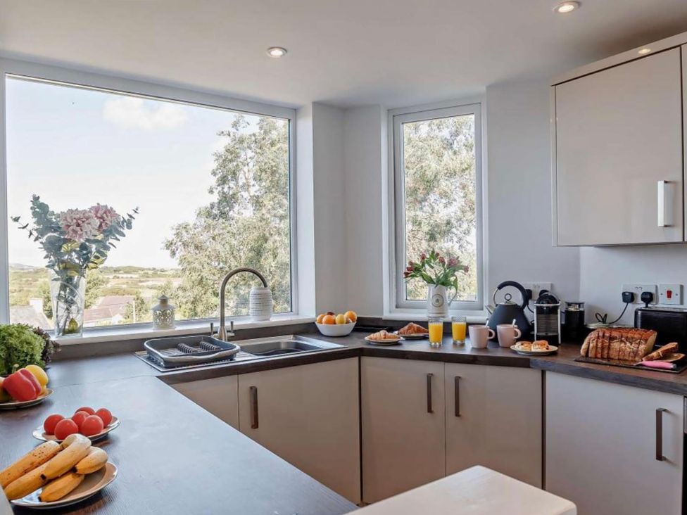A kitchen with windows and breakfast items at Cottage Sleeps 5 with Parking and Garden in Carreglefn