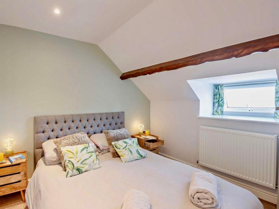 A bedroom with a bed and bedside tables at Cottage Sleeps 5 with Parking and Garden in Carreglefn