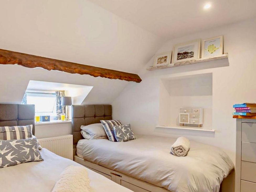 A bedroom with two beds and a shelf in Cottage Sleeps 5 with Parking and Garden Carreglefn