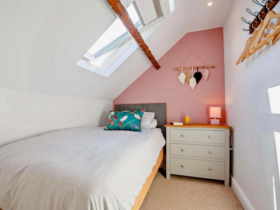 A bedroom with a bed and nightstand at Cottage Sleeps 5 with Parking and Garden, Carreglefn